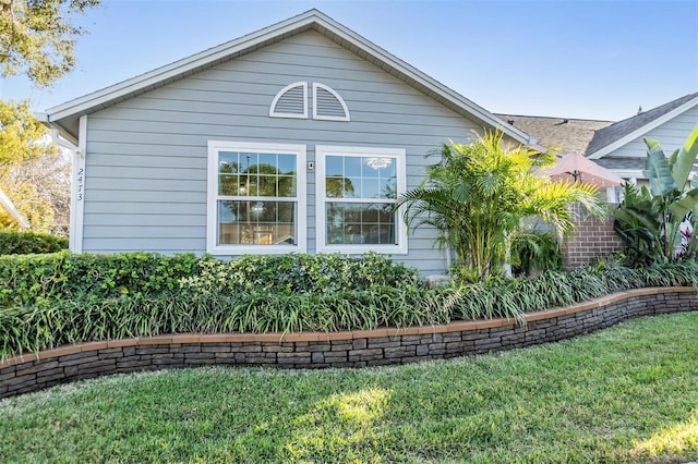 view of property exterior featuring a lawn