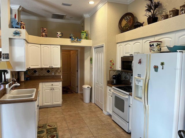 kitchen with white appliances, light tile patterned floors, sink, and white cabinets