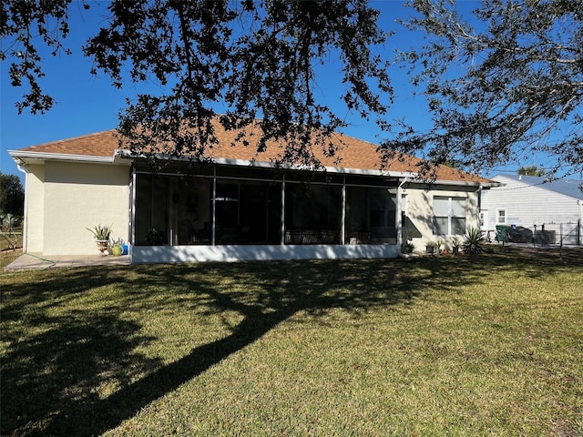 back of property with a lawn and a sunroom