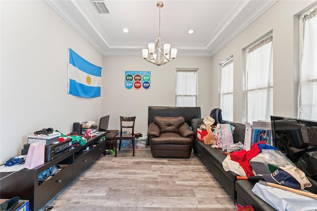 interior space with light wood finished floors, visible vents, a raised ceiling, crown molding, and a chandelier