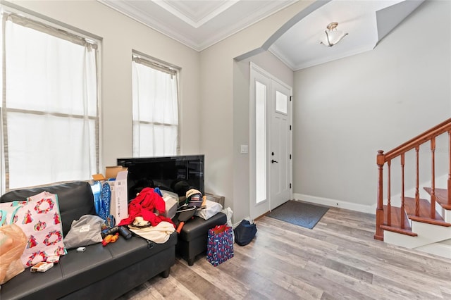 entryway with arched walkways, crown molding, wood finished floors, baseboards, and stairs