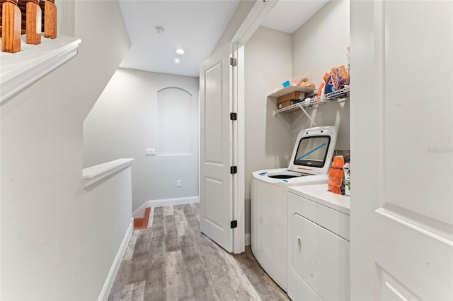 laundry area featuring washer and clothes dryer, recessed lighting, light wood-type flooring, laundry area, and baseboards