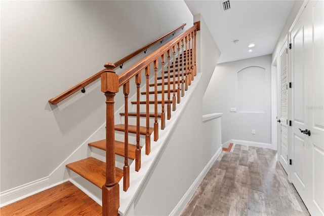 staircase with recessed lighting, wood finished floors, visible vents, and baseboards