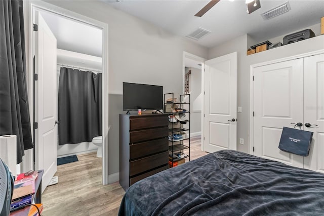 bedroom featuring light wood-type flooring, a ceiling fan, visible vents, and a closet