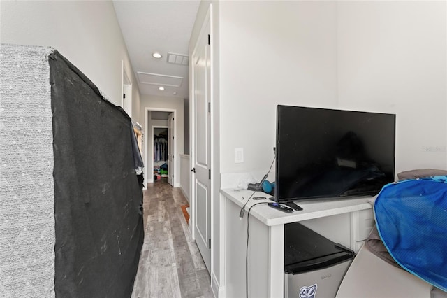 hallway featuring light wood-type flooring, attic access, and recessed lighting