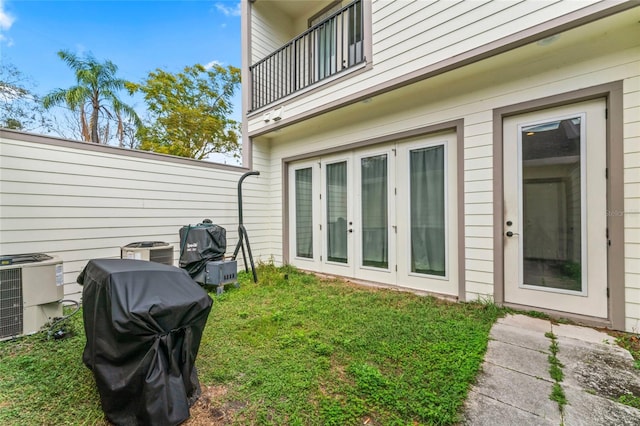 exterior space with french doors, a balcony, and central air condition unit