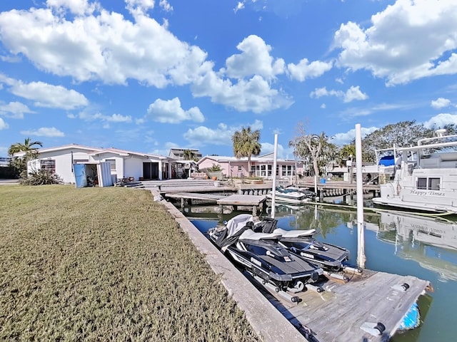 view of dock with a water view and a yard