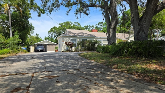 1372 Palmetto St, Clearwater, FL 33755 - view of front of house with driveway, an outbuilding, a chimney, and a garage