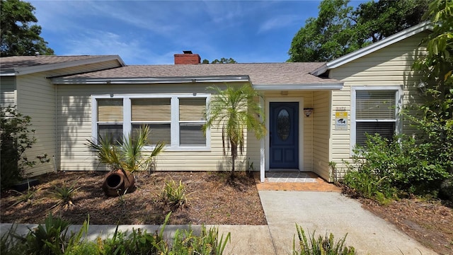 1372 Palmetto St, Clearwater, FL 33755 - doorway to property with a chimney and roof with shingles