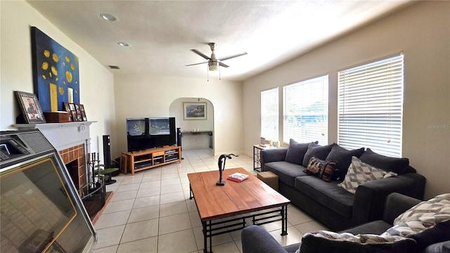 1372 Palmetto St, Clearwater, FL 33755 - living area with a fireplace with raised hearth, light tile patterned floors, visible vents, arched walkways, and ceiling fan