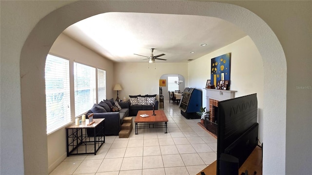 1372 Palmetto St, Clearwater, FL 33755 - living room with a ceiling fan, light tile patterned floors, arched walkways, and baseboards