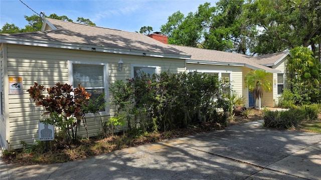 1372 Palmetto St, Clearwater, FL 33755 - view of side of property featuring a chimney and a shingled roof