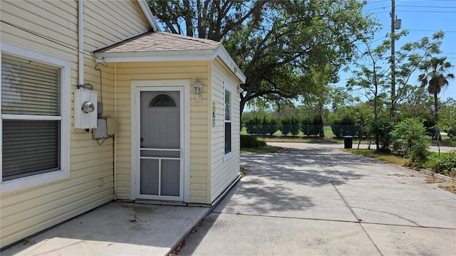 1372 Palmetto St, Clearwater, FL 33755 - doorway to property with driveway, fence, roof with shingles, and a patio area