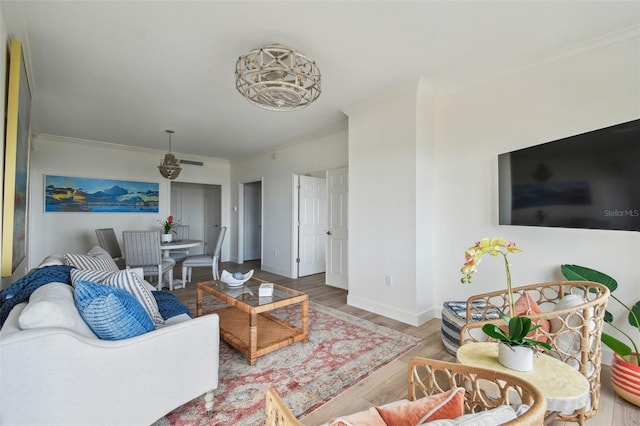 living room with baseboards, visible vents, ornamental molding, and wood finished floors