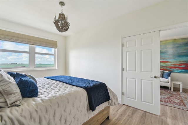 bedroom featuring light wood finished floors and baseboards