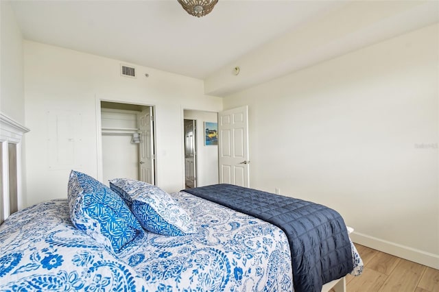 bedroom with light wood-type flooring, visible vents, and baseboards