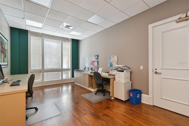 office area featuring a paneled ceiling, wood finished floors, visible vents, and baseboards