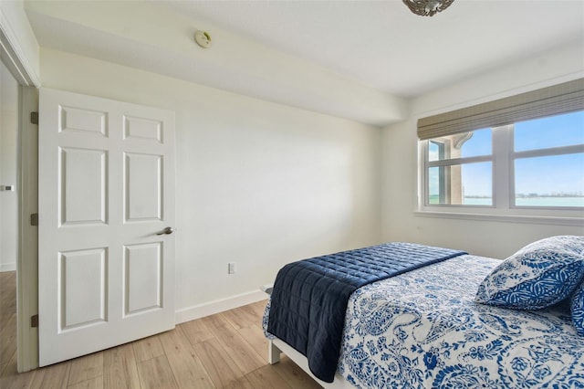 bedroom with light wood-style flooring and baseboards