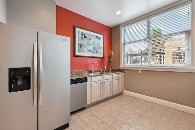 kitchen with light tile patterned floors, recessed lighting, stainless steel appliances, a sink, and baseboards