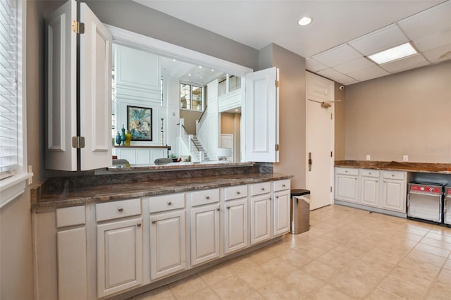 kitchen featuring refrigerator, recessed lighting, a drop ceiling, and white cabinets