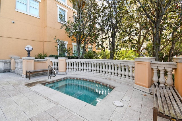 view of swimming pool featuring an in ground hot tub and a patio