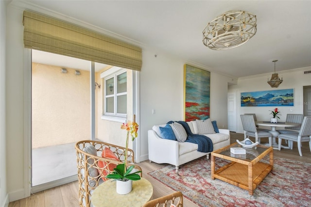 living area featuring wood finished floors, visible vents, and crown molding