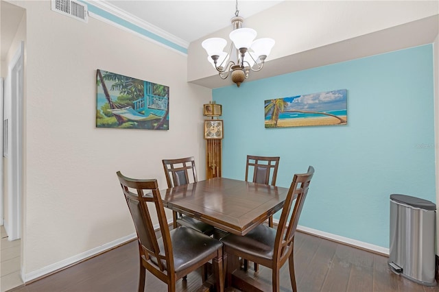 dining area with crown molding, dark wood-type flooring, and a notable chandelier