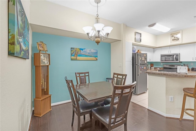 dining space with wood-type flooring and a notable chandelier