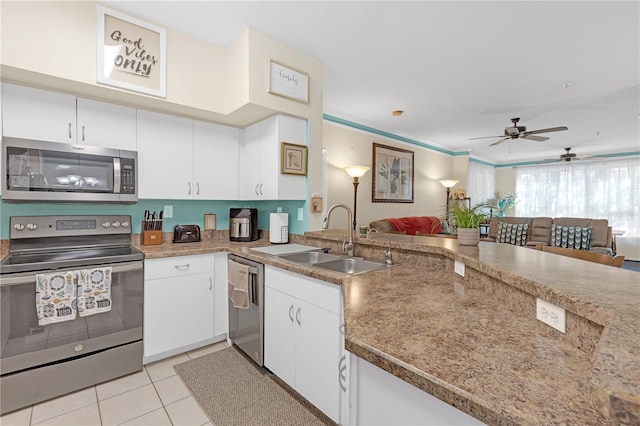 kitchen featuring sink, stainless steel appliances, white cabinets, and light tile patterned flooring