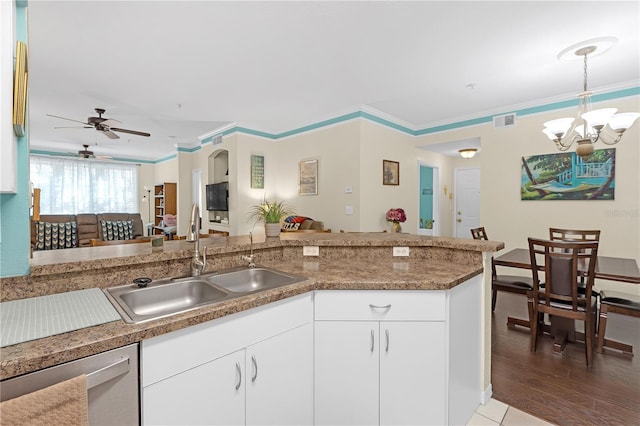 kitchen with pendant lighting, sink, crown molding, white cabinets, and stainless steel dishwasher