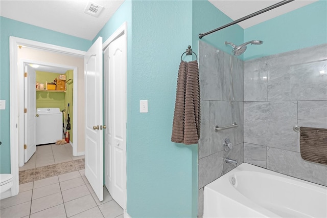 bathroom with toilet, washer / clothes dryer, tiled shower / bath combo, and tile patterned flooring