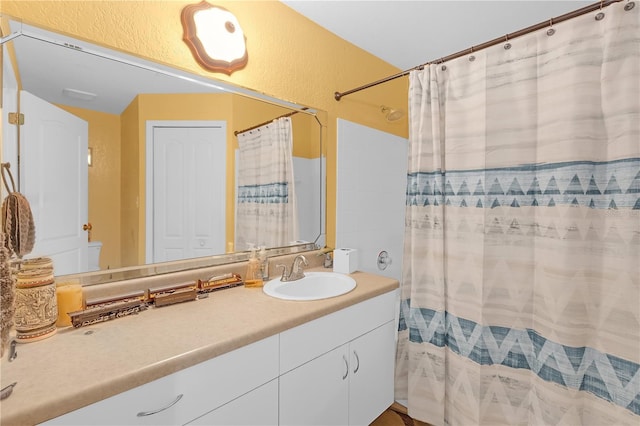 bathroom featuring vanity and curtained shower