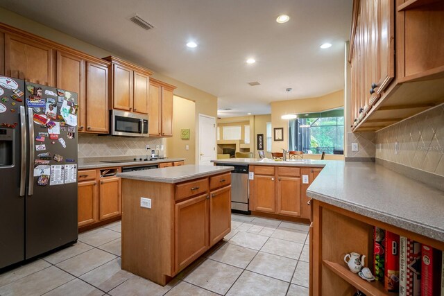 10534 Bermuda Isle Dr, Tampa, FL 33647 - kitchen with sink, appliances with stainless steel finishes, a kitchen island, light tile patterned flooring, and kitchen peninsula