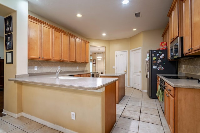 10534 Bermuda Isle Dr, Tampa, FL 33647 - kitchen with black appliances, sink, light tile patterned floors, and kitchen peninsula