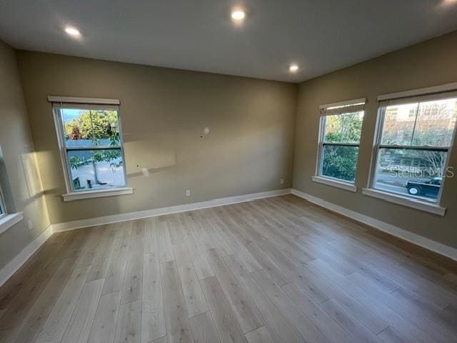 unfurnished room with a healthy amount of sunlight and light hardwood / wood-style flooring