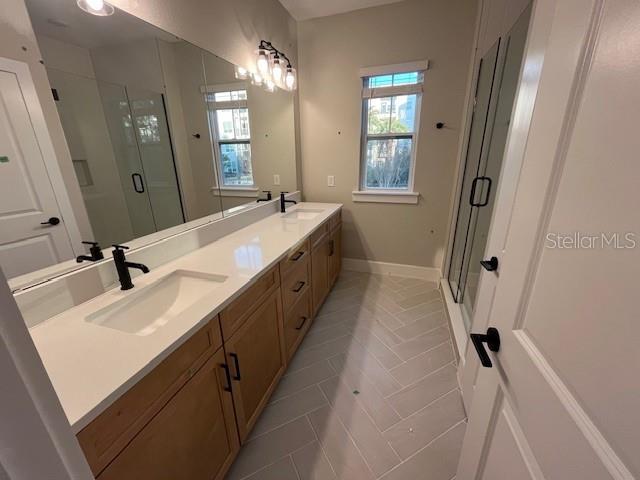 bathroom with vanity and a shower with door