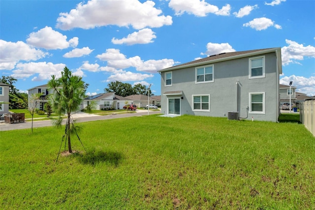 back of property with cooling unit and a lawn