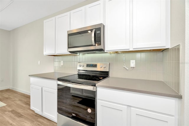 kitchen with white cabinetry, tasteful backsplash, light hardwood / wood-style floors, and appliances with stainless steel finishes