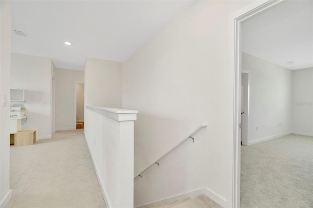 hallway featuring light colored carpet