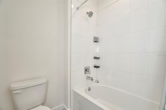 bathroom featuring toilet and tiled shower / bath