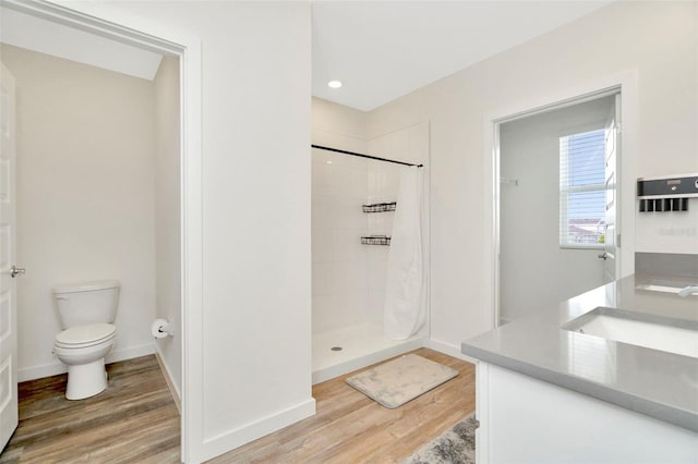 bathroom featuring hardwood / wood-style floors, vanity, curtained shower, and toilet