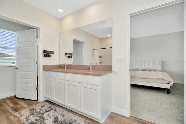 bathroom featuring wood-type flooring, a shower, and vanity