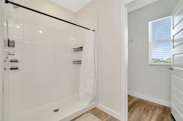 bathroom with hardwood / wood-style flooring and a shower with shower curtain