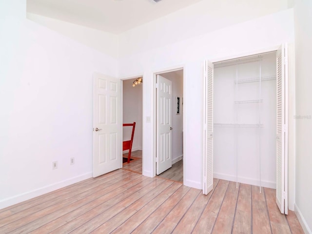 unfurnished bedroom with a closet and light wood-type flooring