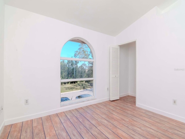 empty room featuring lofted ceiling and light hardwood / wood-style floors