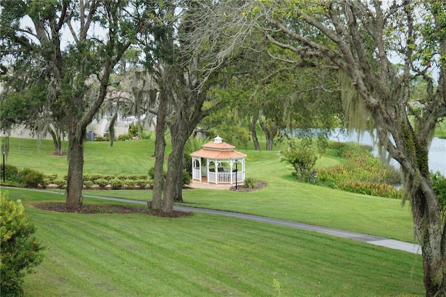 surrounding community with a gazebo, a lawn, and a water view