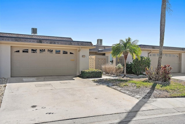 single story home featuring a garage and central AC unit