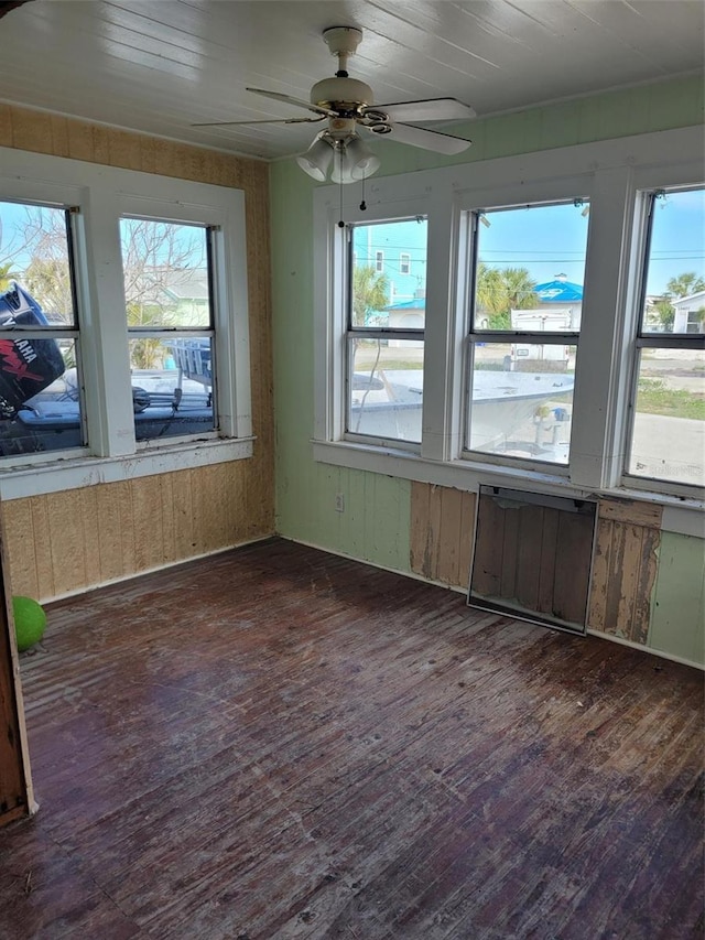 unfurnished sunroom featuring radiator and ceiling fan