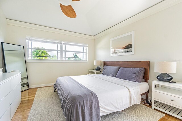 bedroom featuring ceiling fan, lofted ceiling, light hardwood / wood-style flooring, and ornamental molding