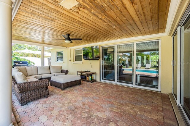 sunroom with ceiling fan, plenty of natural light, and wooden ceiling